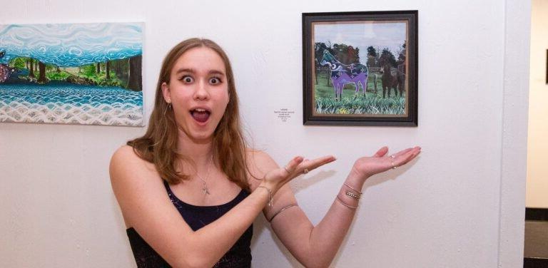 A student shows off her art project.